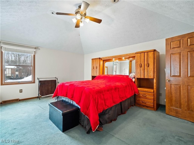 bedroom with ceiling fan, lofted ceiling, light colored carpet, and a textured ceiling