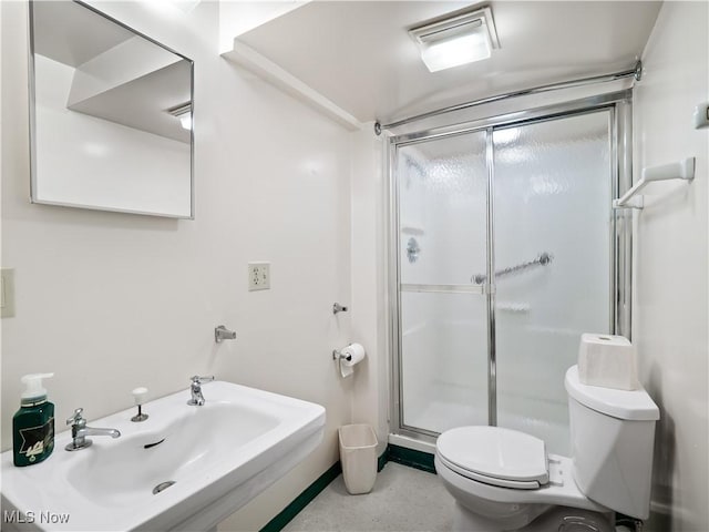 bathroom with sink, toilet, and a shower with door