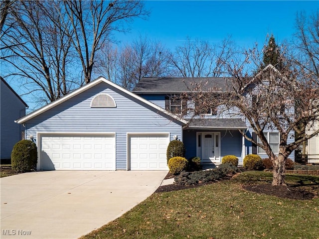 traditional-style home with driveway, a front lawn, and a garage