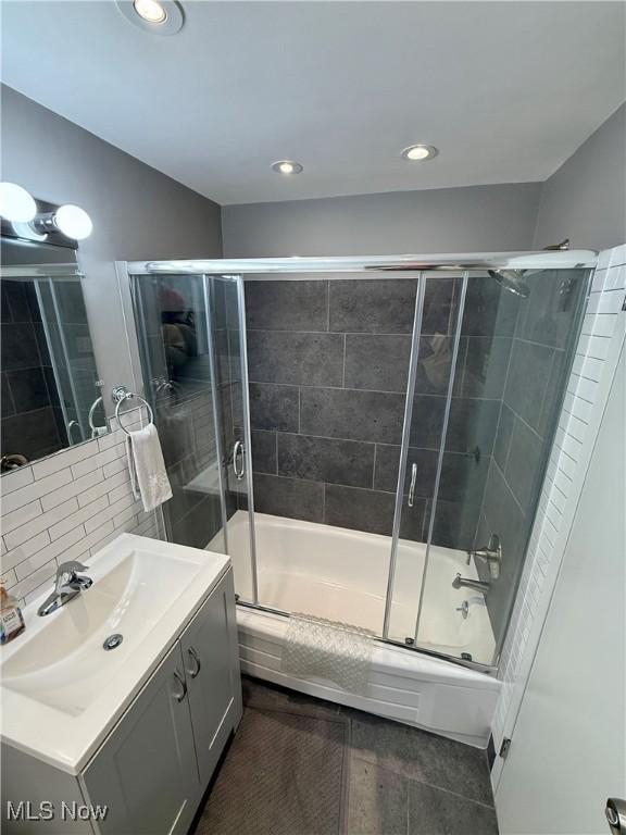 bathroom with vanity, tile patterned flooring, bath / shower combo with glass door, and tasteful backsplash