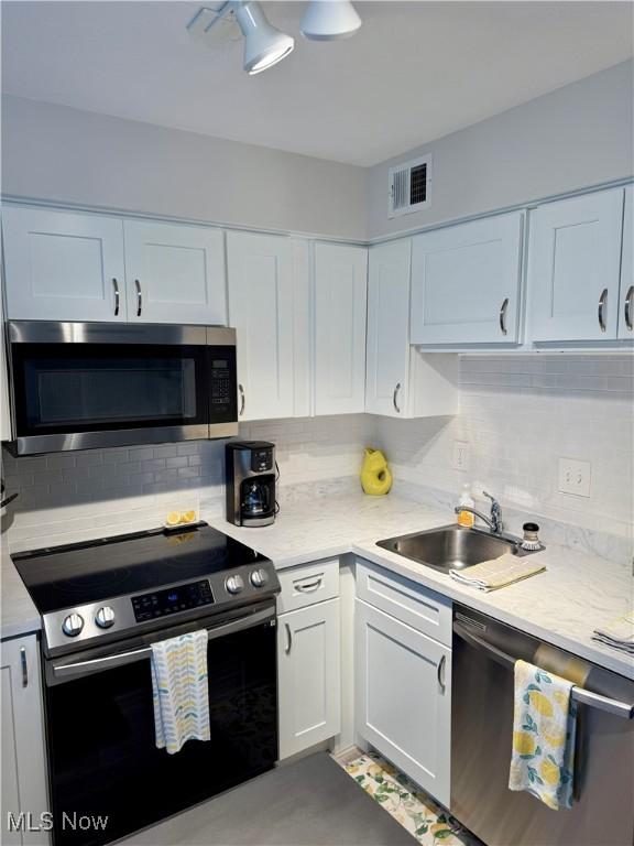 kitchen with sink, white cabinets, and appliances with stainless steel finishes