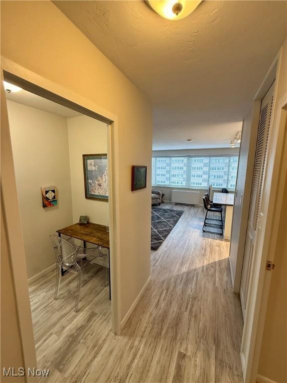 corridor featuring hardwood / wood-style flooring and a textured ceiling