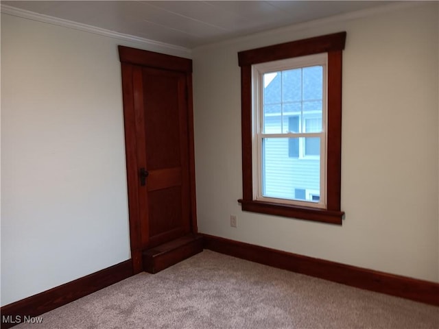 carpeted spare room with crown molding