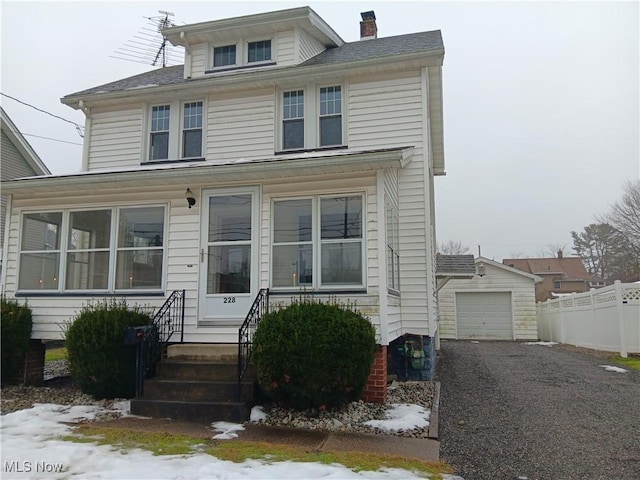 view of front of property featuring a garage and an outdoor structure