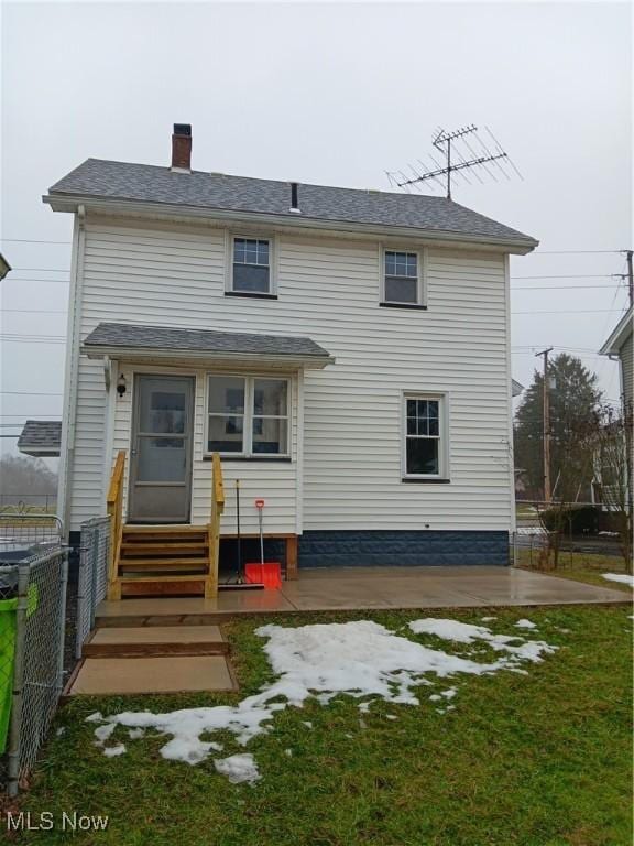 back of property with a patio area and a lawn