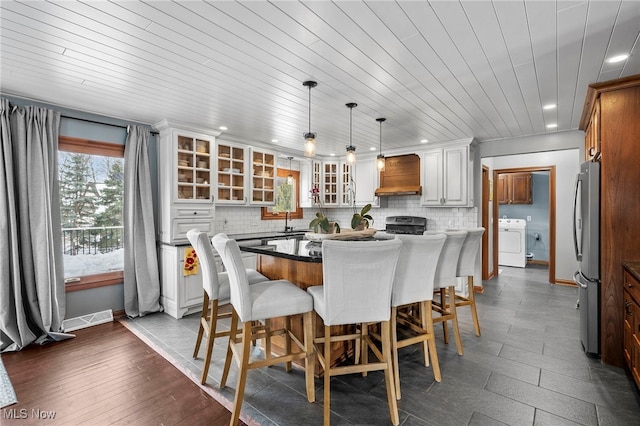 dining room featuring wood ceiling, visible vents, baseboards, and washer / dryer