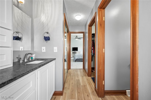 interior space with a textured ceiling, light wood-type flooring, and a sink