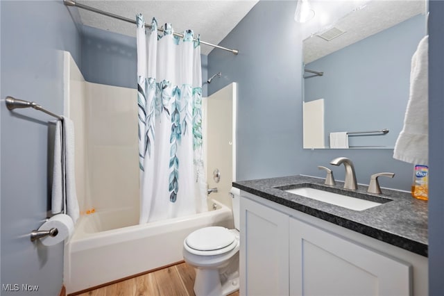 full bath with wood finished floors, visible vents, shower / tub combo with curtain, and a textured ceiling