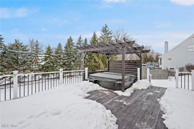 snow covered deck featuring fence, a pergola, and a hot tub