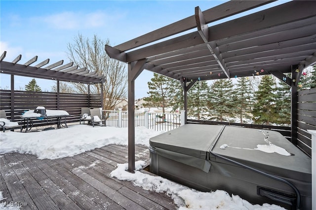 snow covered deck featuring a pergola and a hot tub