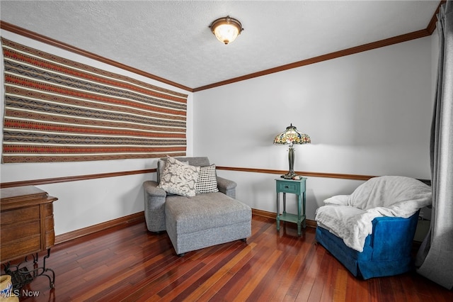 living area with a textured ceiling, crown molding, baseboards, and wood-type flooring