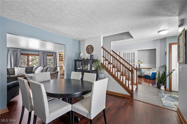 dining space featuring stairway, a textured ceiling, and wood-type flooring