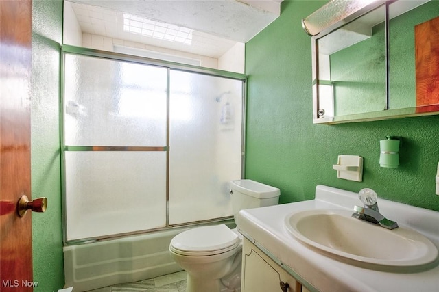 full bathroom featuring bath / shower combo with glass door, vanity, and toilet