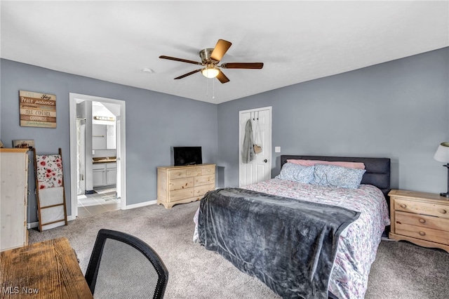 bedroom featuring connected bathroom, light colored carpet, a closet, and ceiling fan