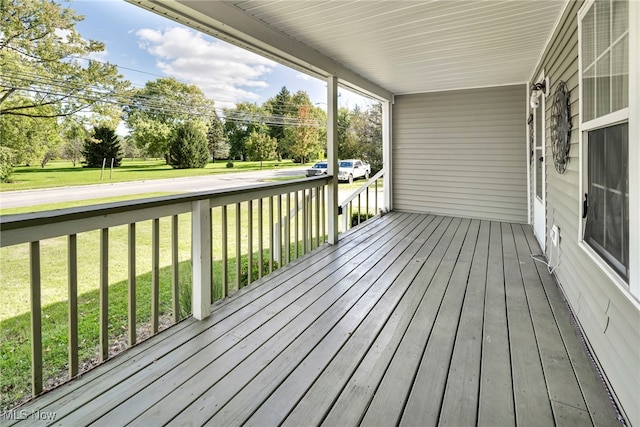 wooden terrace with a porch and a yard