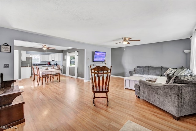 living room featuring light hardwood / wood-style floors and ceiling fan