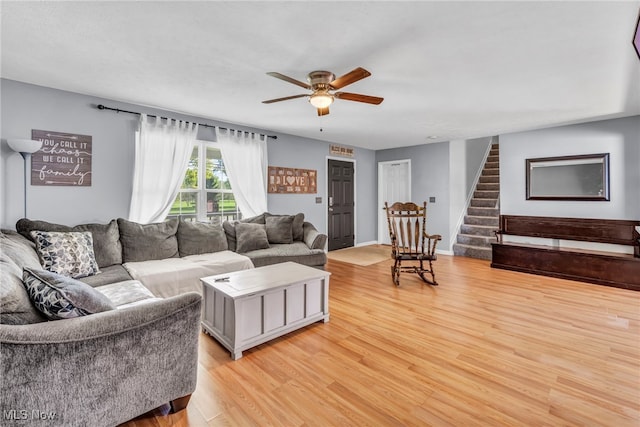 living room featuring light hardwood / wood-style flooring and ceiling fan