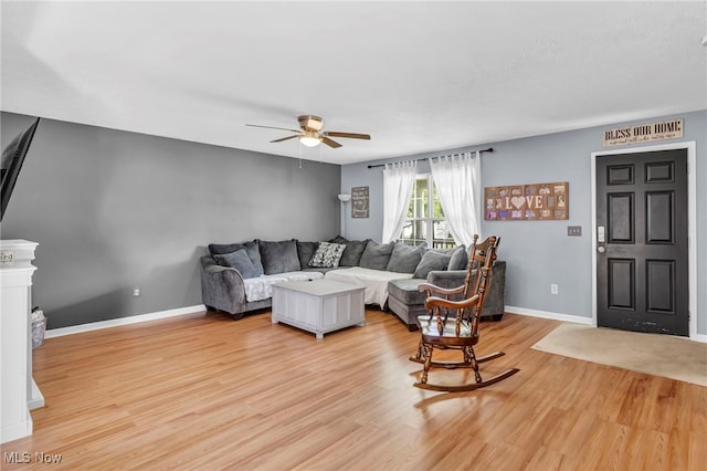 living room with light hardwood / wood-style flooring and ceiling fan