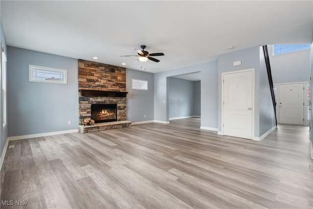 unfurnished living room featuring light hardwood / wood-style flooring, a fireplace, and ceiling fan