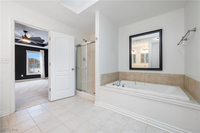 bathroom featuring a skylight, shower with separate bathtub, and ceiling fan