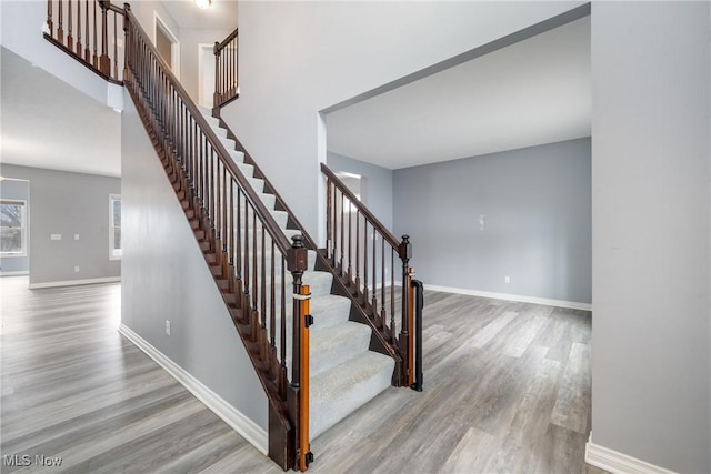 stairway featuring wood-type flooring and a high ceiling