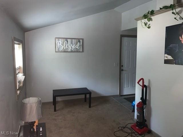 interior space with lofted ceiling and dark colored carpet