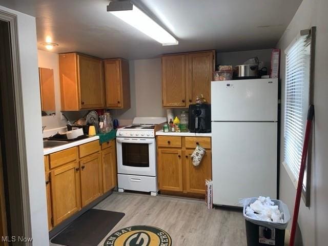 kitchen featuring white appliances and light hardwood / wood-style floors