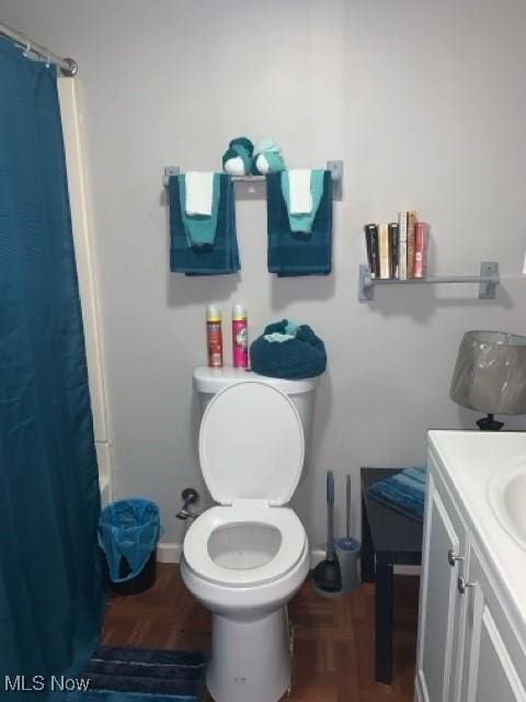 bathroom with vanity, parquet floors, and toilet