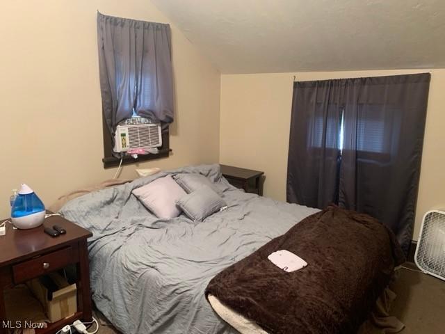 bedroom with lofted ceiling and cooling unit