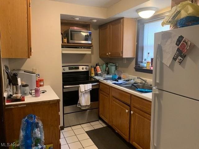 kitchen featuring sink, stainless steel appliances, and light tile patterned flooring