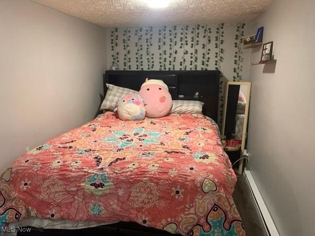 bedroom with a baseboard radiator and a textured ceiling