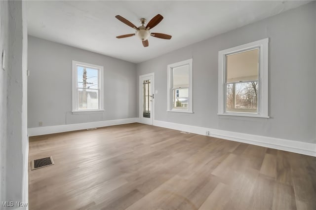 unfurnished room featuring ceiling fan, a healthy amount of sunlight, and light hardwood / wood-style flooring