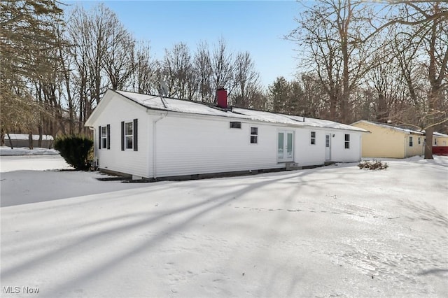 view of snow covered back of property