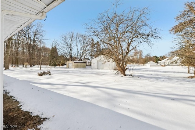 snowy yard with a shed