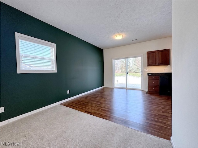 unfurnished living room with wood-type flooring and a textured ceiling