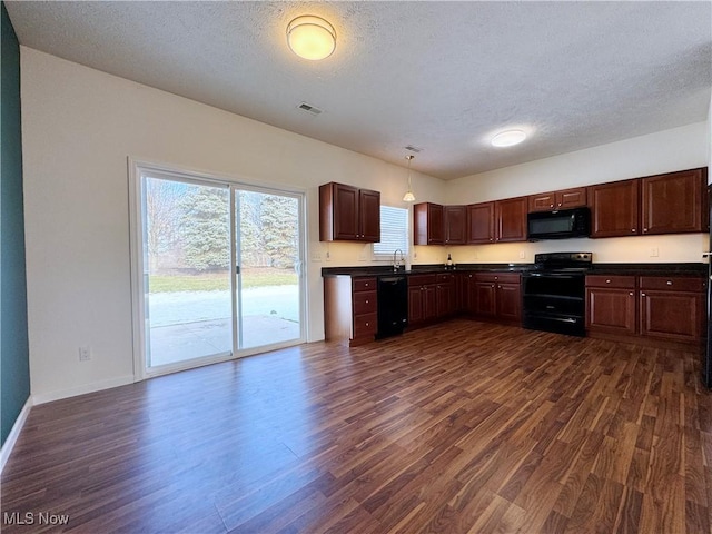 kitchen with dark hardwood / wood-style floors, hanging light fixtures, and black appliances