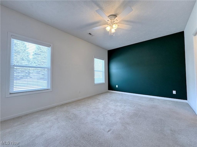 unfurnished room featuring ceiling fan, carpet, and a textured ceiling