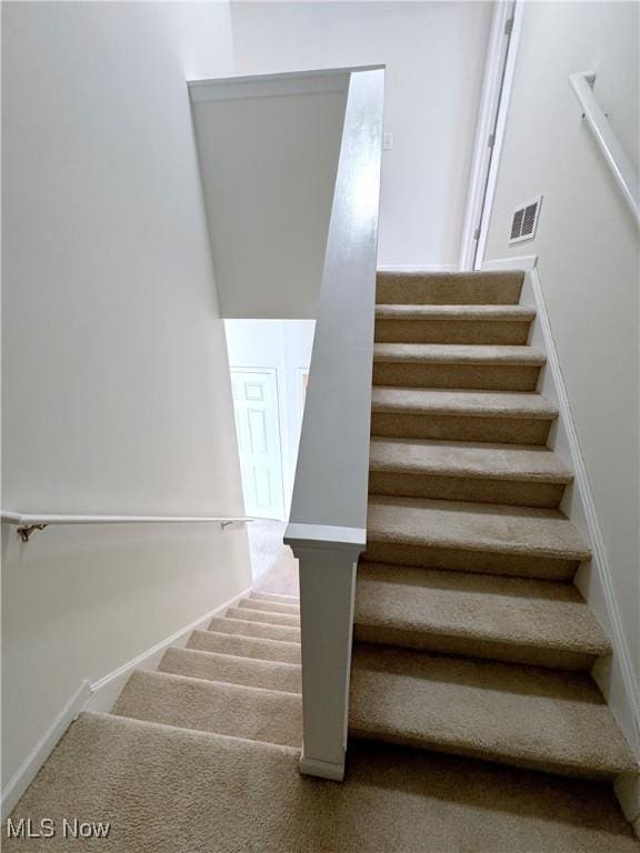 stairs featuring carpet flooring