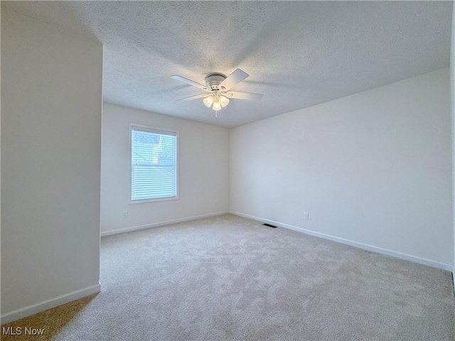 carpeted empty room with a textured ceiling and ceiling fan