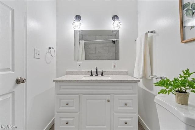 bathroom featuring vanity, toilet, and curtained shower