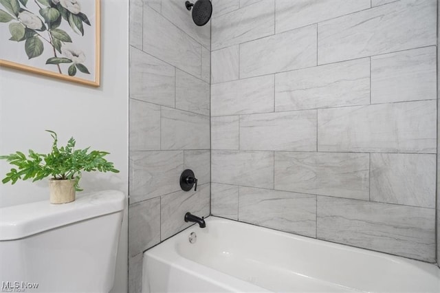 bathroom featuring tiled shower / bath combo and toilet