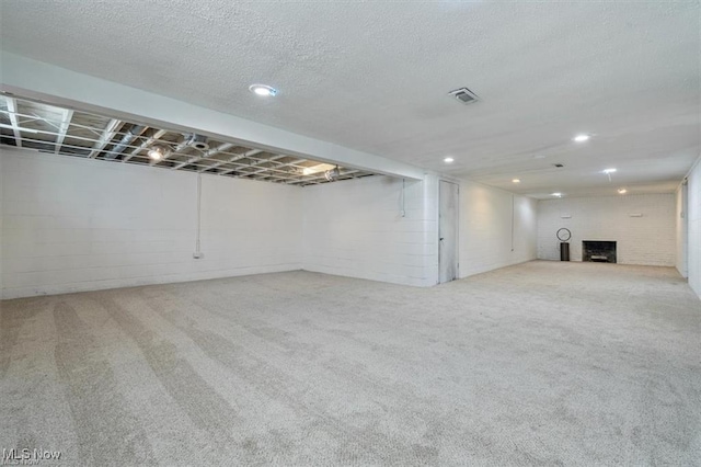 basement with light colored carpet and a textured ceiling