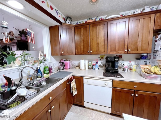 kitchen with sink, dishwasher, and a textured ceiling