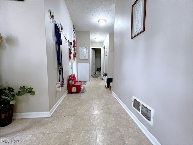 hall with a textured ceiling