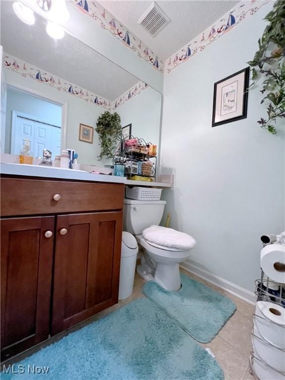 bathroom with tile patterned flooring, vanity, and toilet