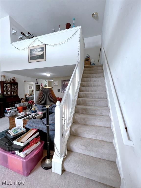 stairway featuring carpet