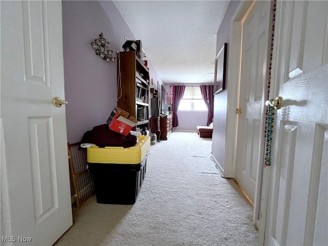 hallway featuring light colored carpet