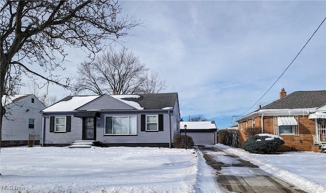 bungalow featuring a garage and an outbuilding