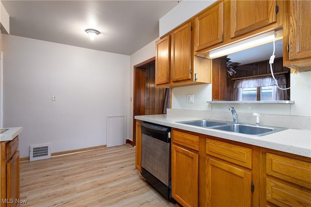 kitchen with black dishwasher, sink, and light wood-type flooring