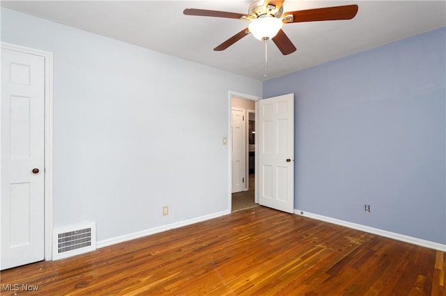 unfurnished room featuring dark wood-type flooring and ceiling fan